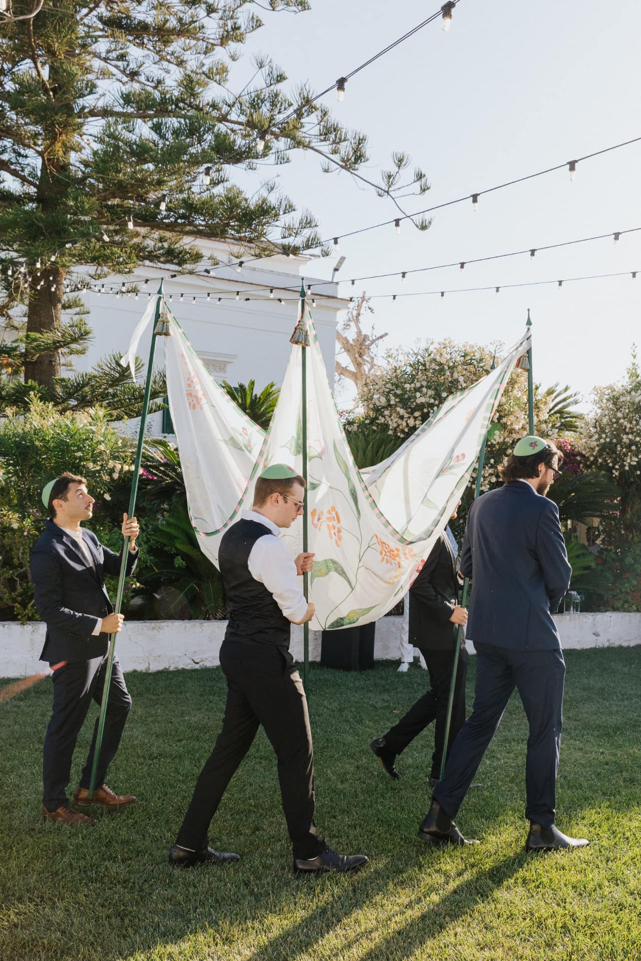 Porteurs accompagnant le voile de cérémonie dans un jardin